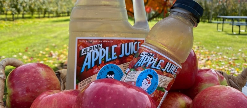 Bottles of Alpine Apple Juice with apples